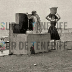 Una mujer y una niñas sacando agua de una fuente en el sur de tenerife, fotos antiguas